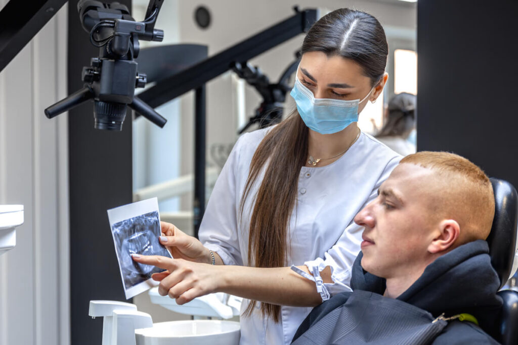 Pourquoi un suivi dentaire régulier ne doit jamais être négligé 3 Dentiste expliquant une radiographie de contrôle lors d'un suivi dentaire.
