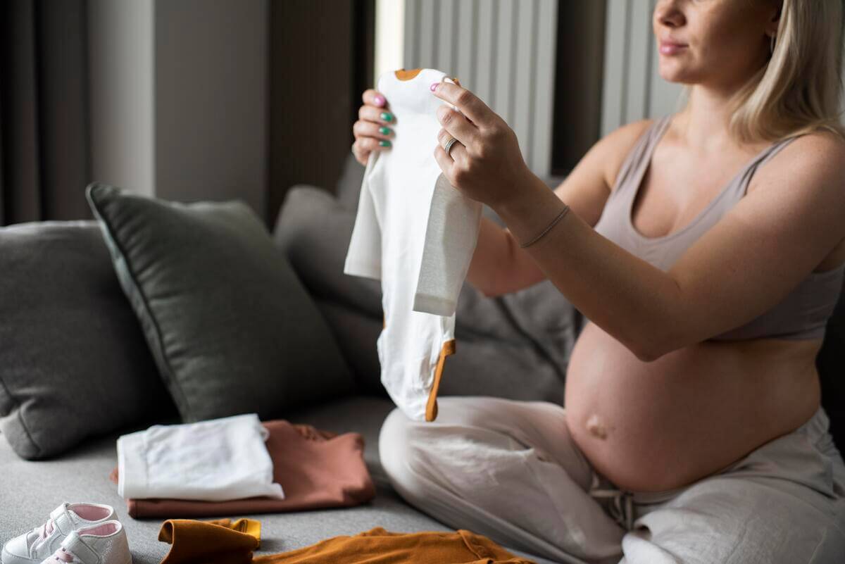 Vêtements de naissance et accessoires soigneusement pliés dans une valise de maternité pour bébé.