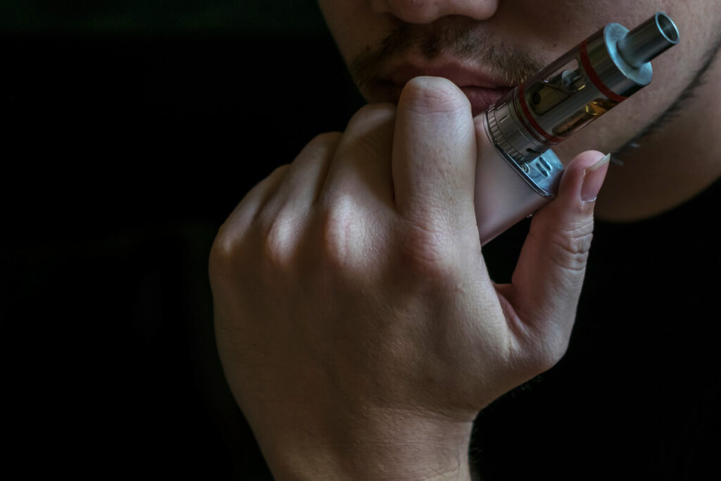 Cigarette électronique aux sels de nicotine : ce qu'il faut savoir avant de se lancer 3 Vapoteur utilisant une e-cigarette à tirage serré pour un sevrage avec sels de nicotine.