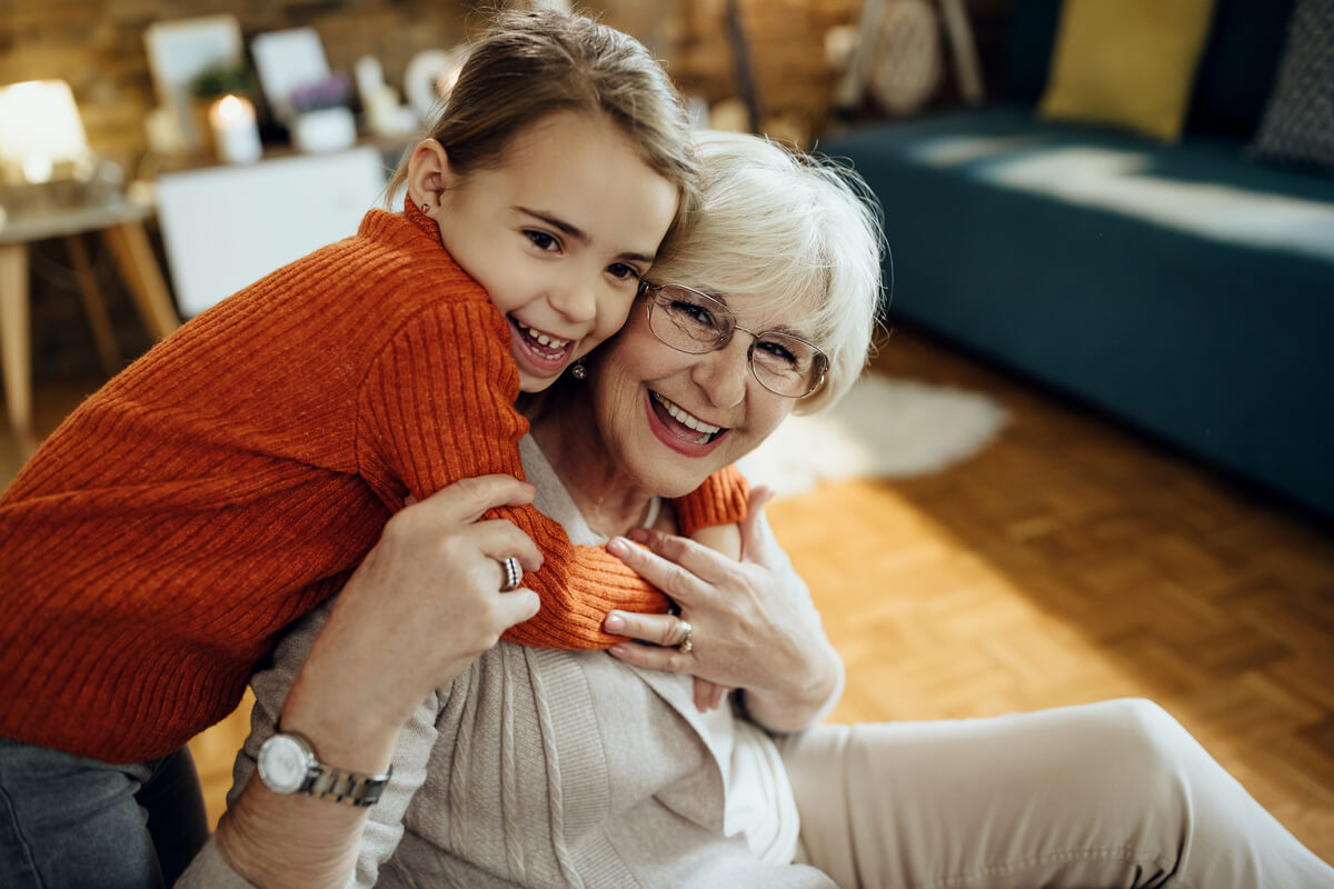 Femme dynamique et souriante de cinquante ans partageant un moment de complicité avec son petit-fils.