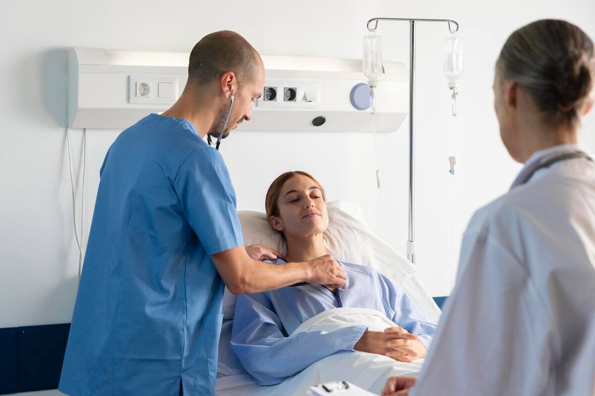 Patient en salle de réveil portant la main à sa gorge irritée après une anesthésie générale.
