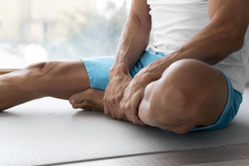 Quel est l’intérêt de prendre du collagène ? 3 Sportif massant son genou pour préserver ses cartilages et sa souplesse articulaire grâce au collagène.