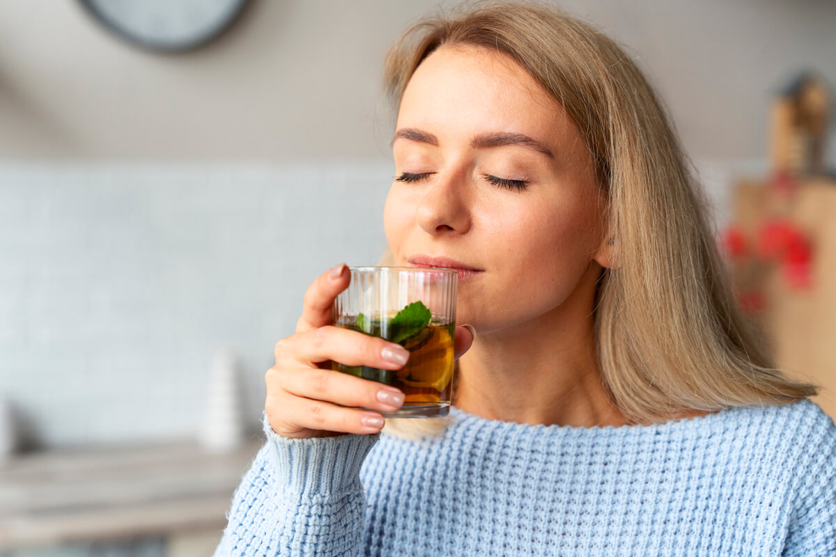 Tasse d'infusion de feuilles de menthe poivrée fraîche préparée pour freiner la lactation.