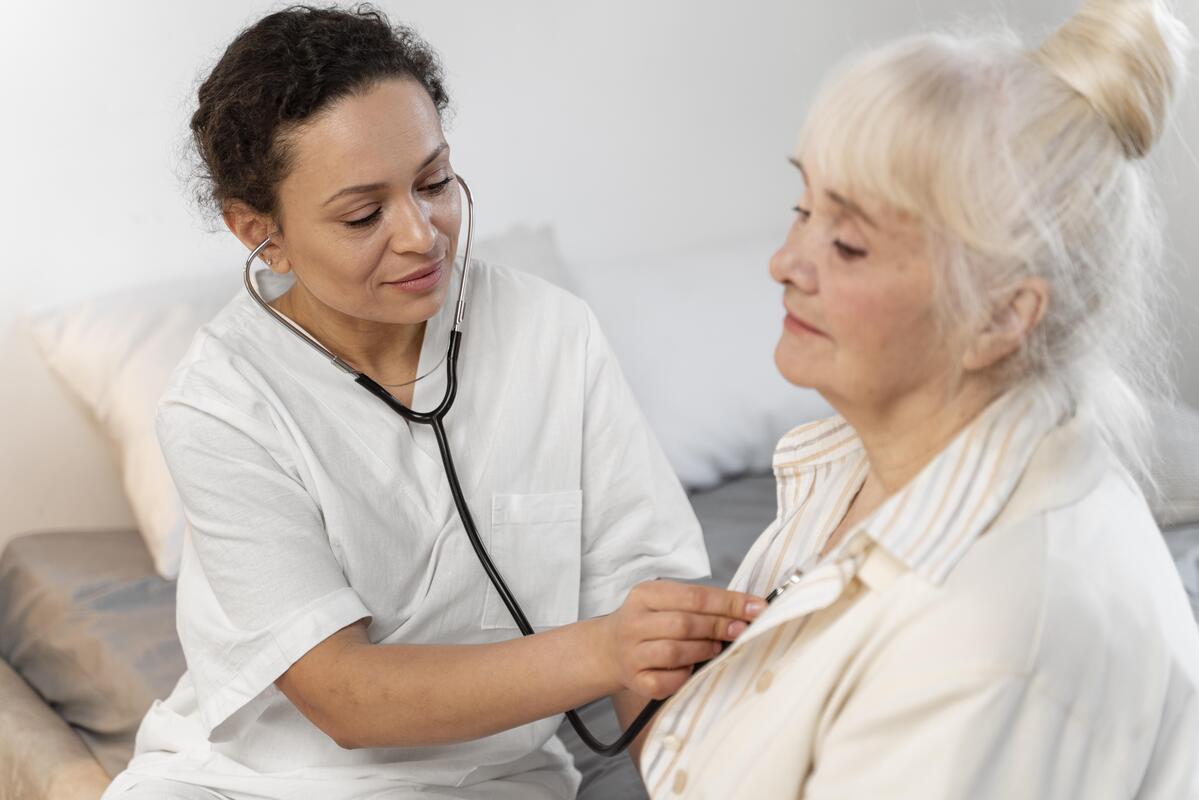 Médecin généraliste utilisant un stéthoscope pour écouter le souffle au cœur d'un patient de plus de 65 ans.