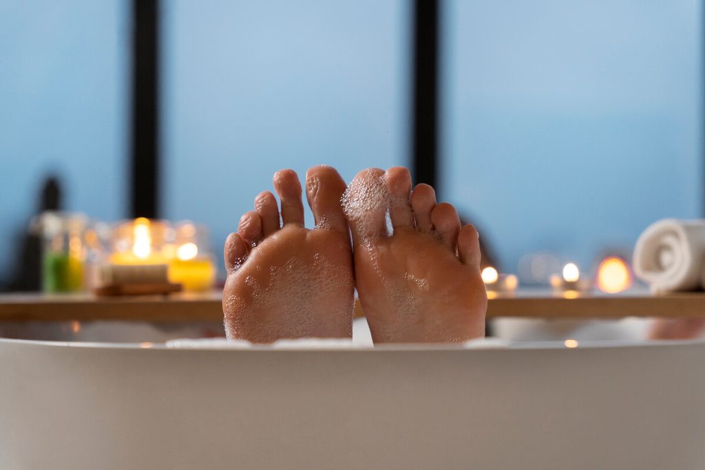 Bain de pieds délassant dans une bassine d'eau tiède pour calmer les échauffements.