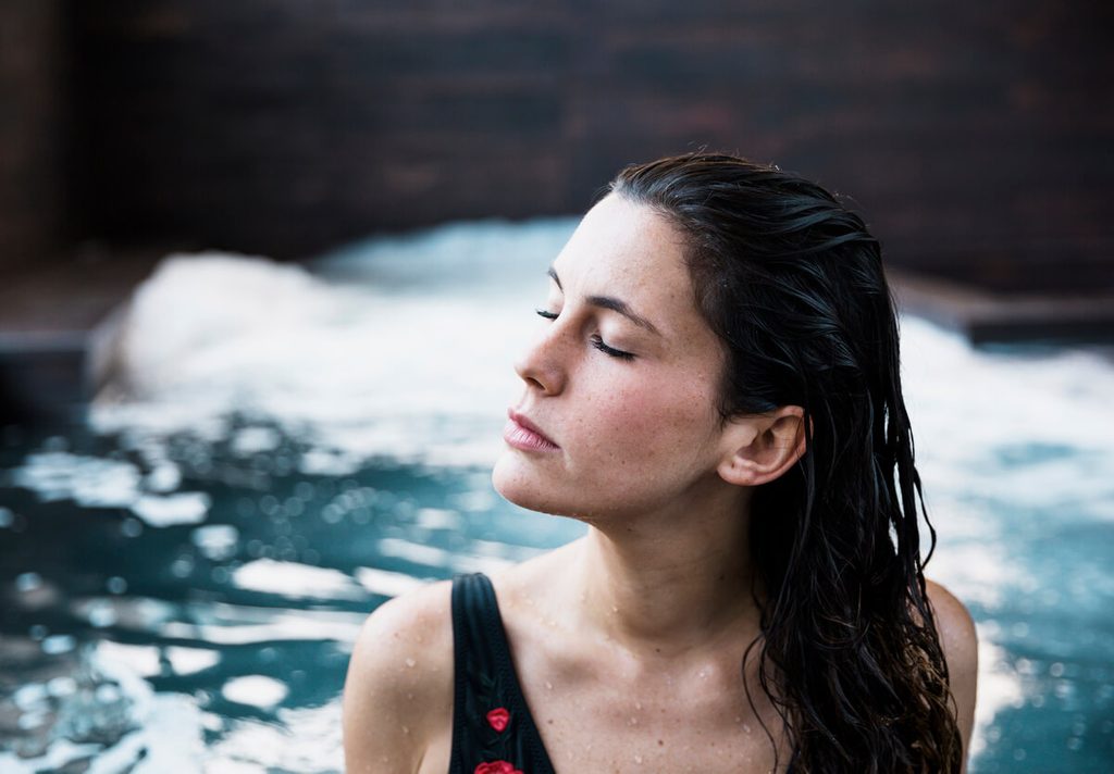 Pourquoi associer thalassothérapie et sport pendant une cure à l'Île de Ré ? 3 Curiste détendant ses muscles sous un jet massant d'eau de mer chaude dans un centre de thalassothérapie.