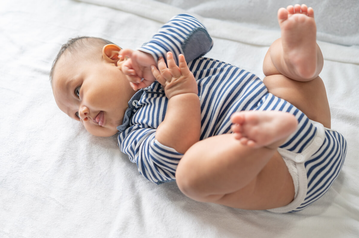 Nourrisson repliant ses jambes sur son ventre en raison de ballonnements intestinaux douloureux.