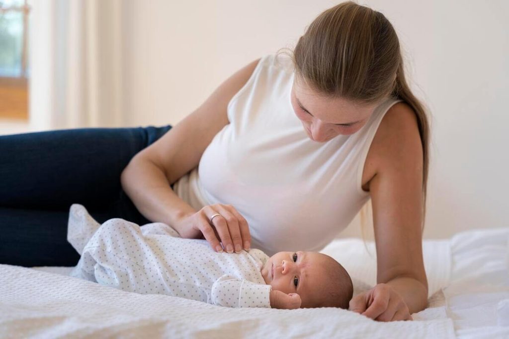 Gaz malodorant chez le bébé allaité : causes réelles et solutions digestives 4 Mains d'un parent massant délicatement le ventre d'un bébé allaité pour évacuer les gaz.