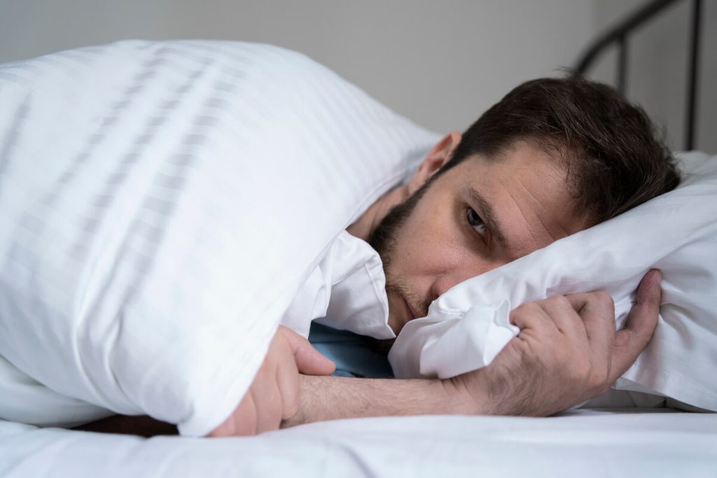 Néo-Mercazole et sommeil : insomnies, fatigue et réglage du dosage 3 Personne réveillée la nuit dans son lit cherchant le sommeil en raison d'un dérèglement thyroïdien.